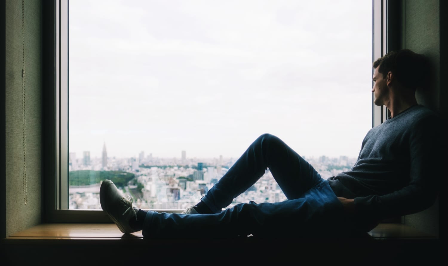 Man sitting alone by window- Psychological trauma