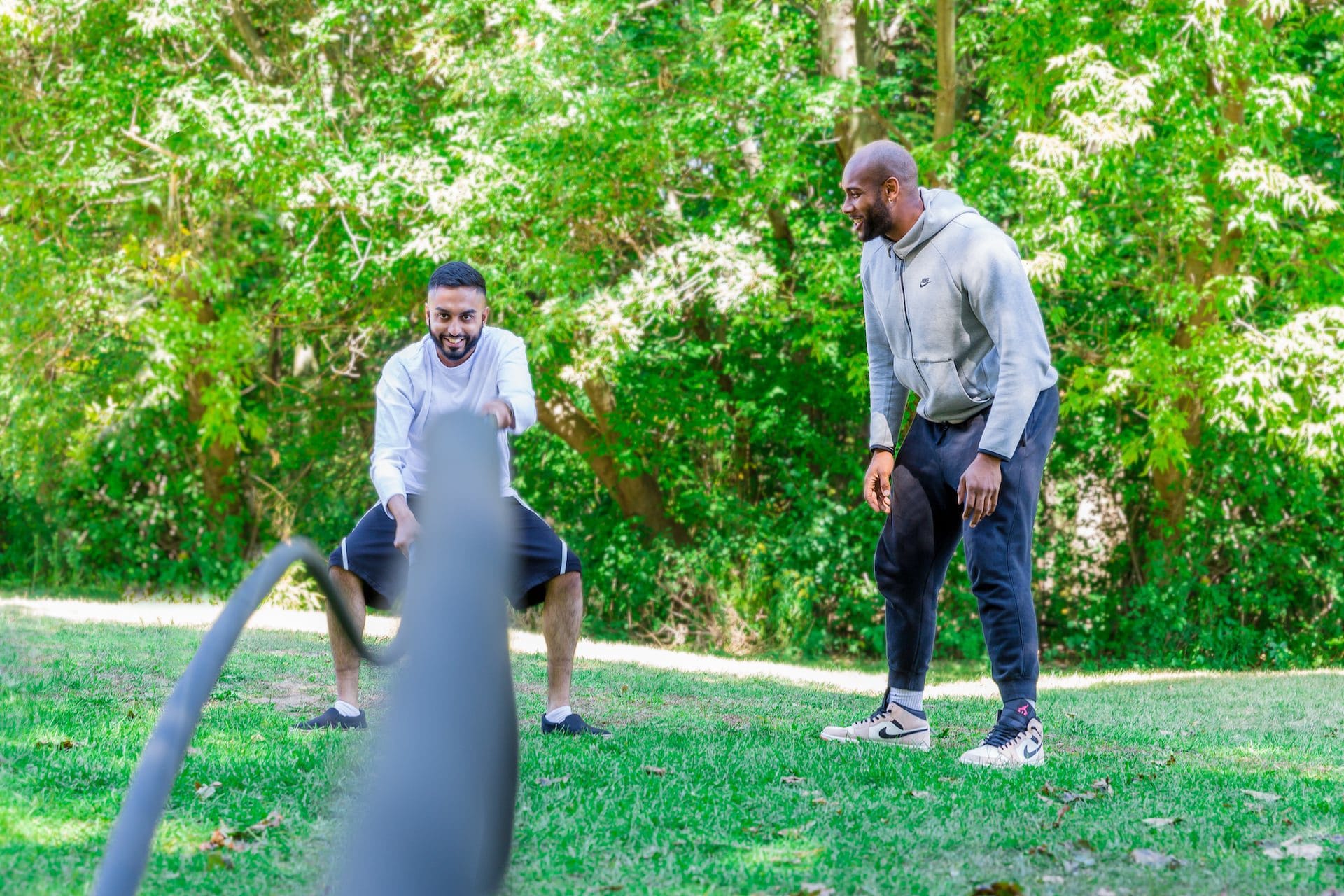 Two men outside working out with ropes