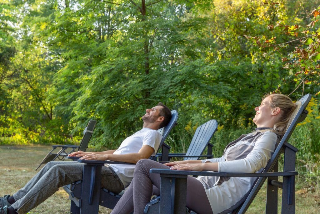 Two people sitting on chairs outside