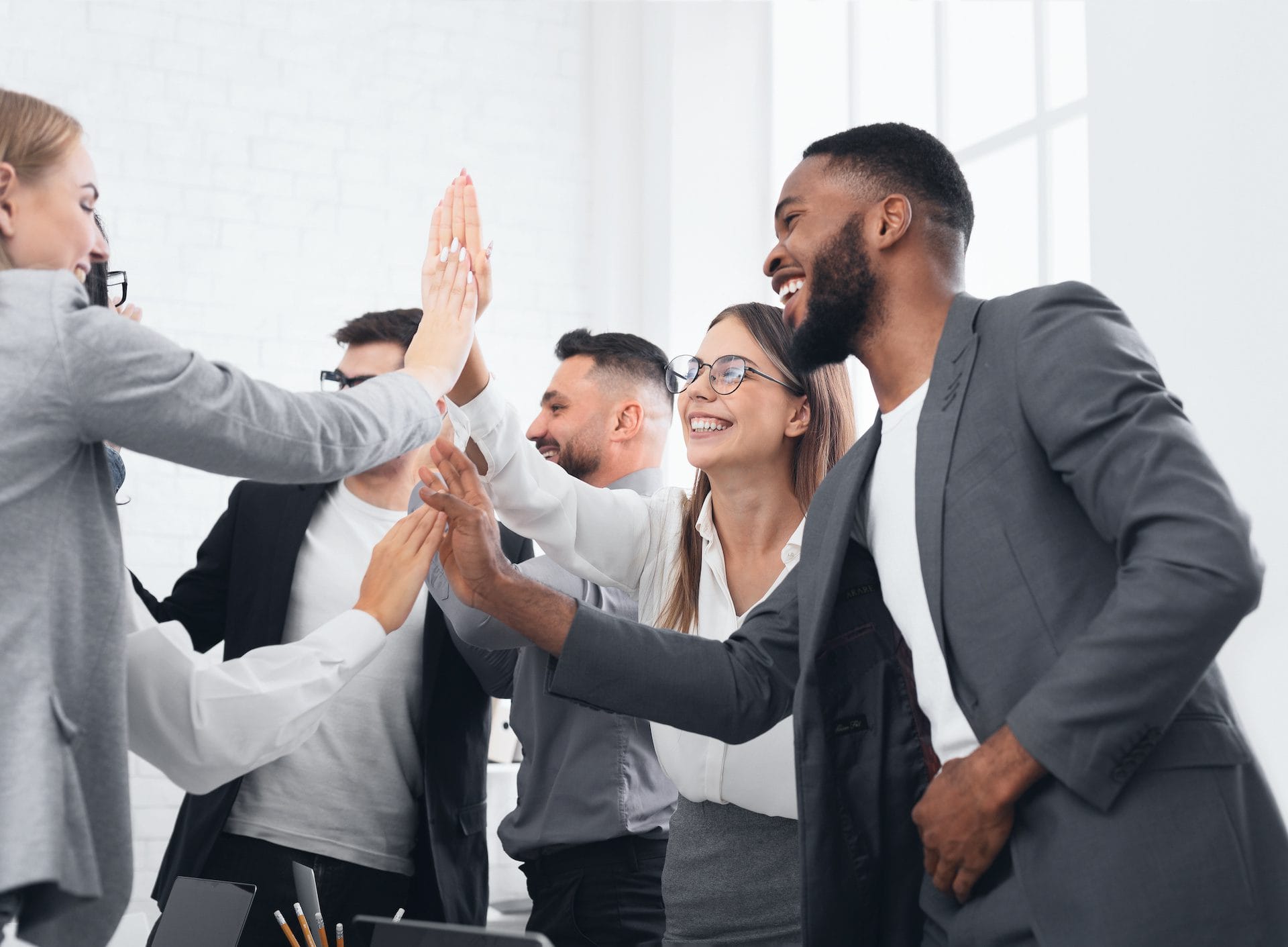 Business team giving group high five, celebrating