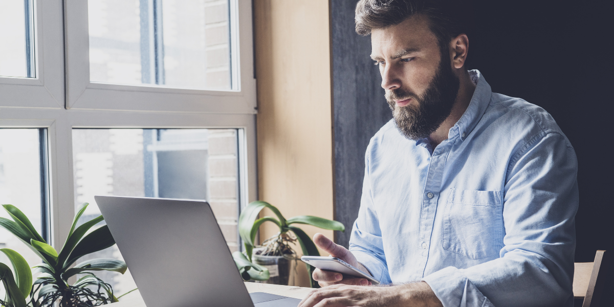 man attentively looking at laptop