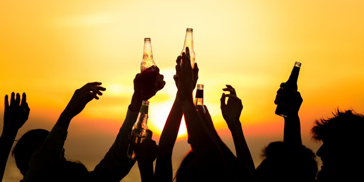 people holding beer sunset background