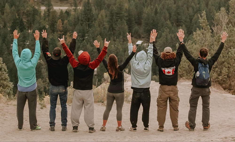 Group of people raising their hands up after going through addiction and mental health treatment