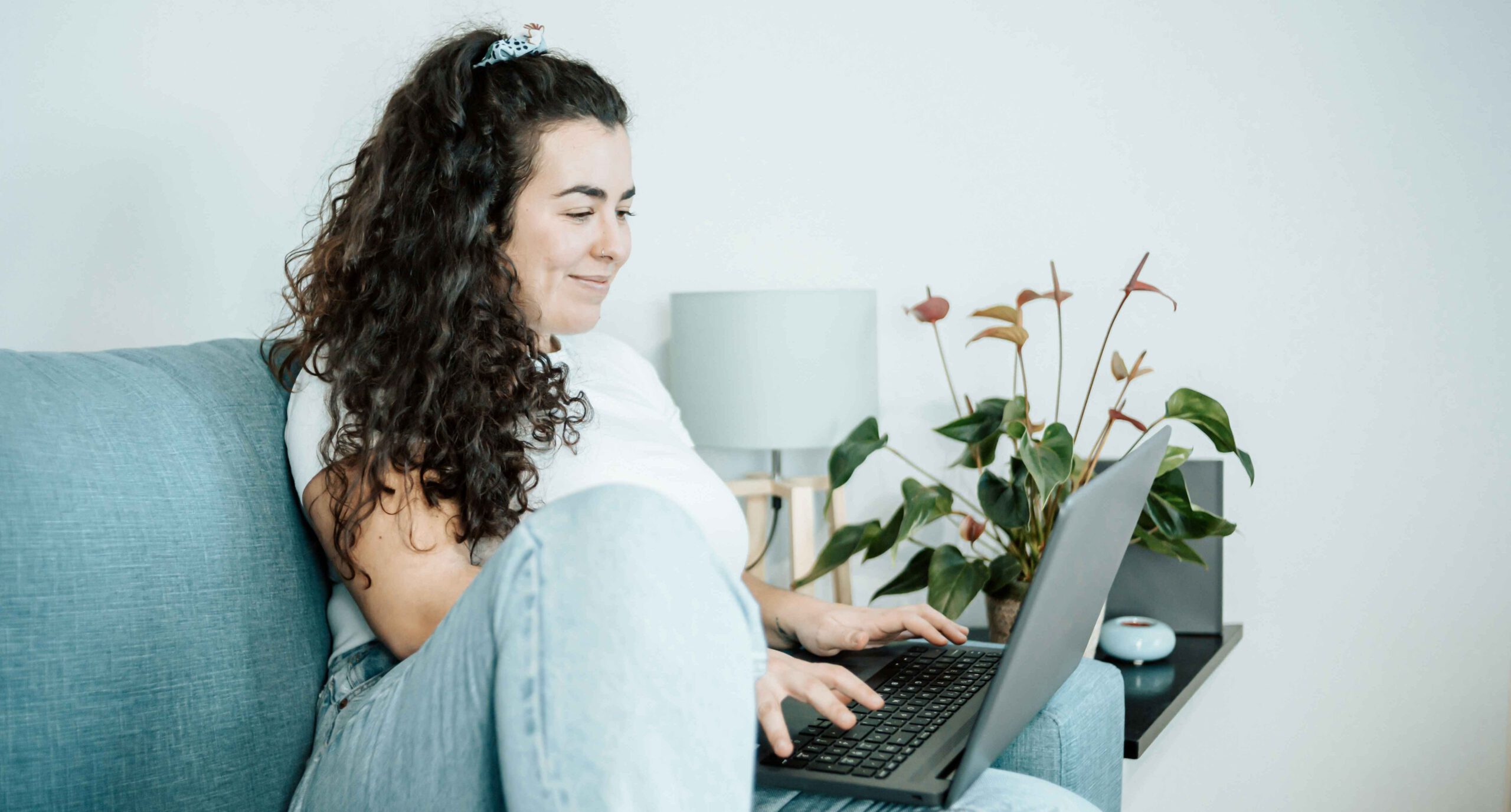 A woman sitting on a couch on her laptop