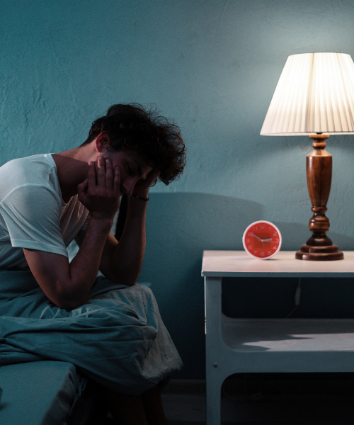 man with hands on head in bed